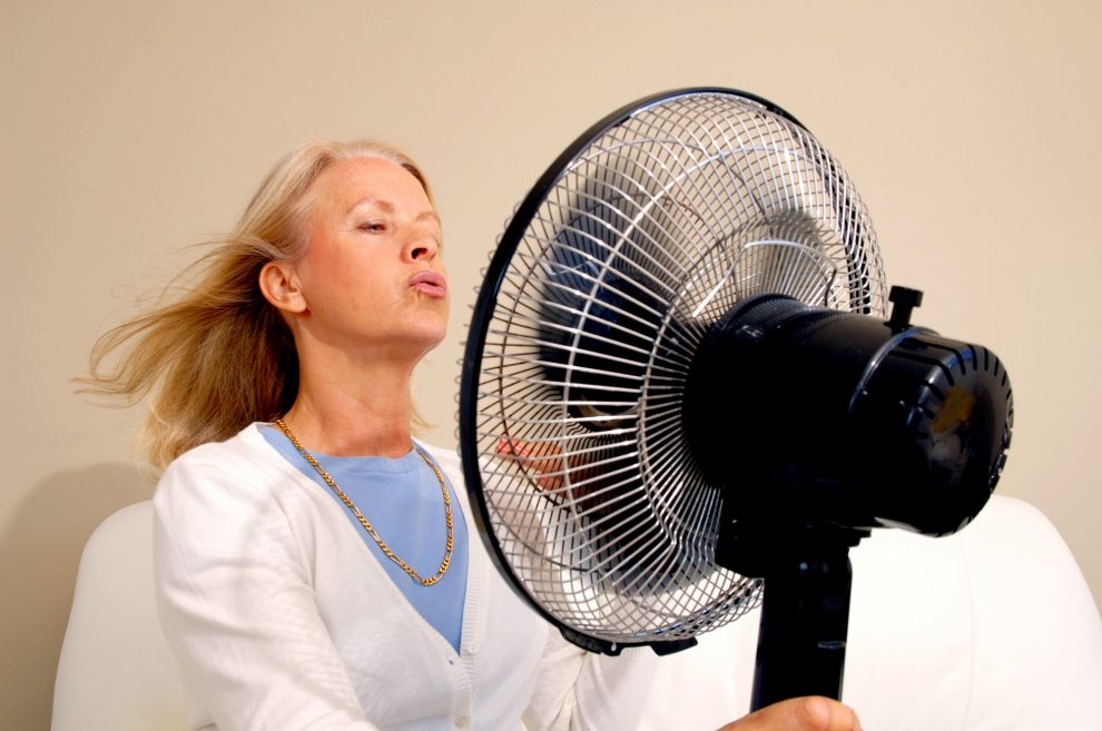 Lady with fan hot flushes