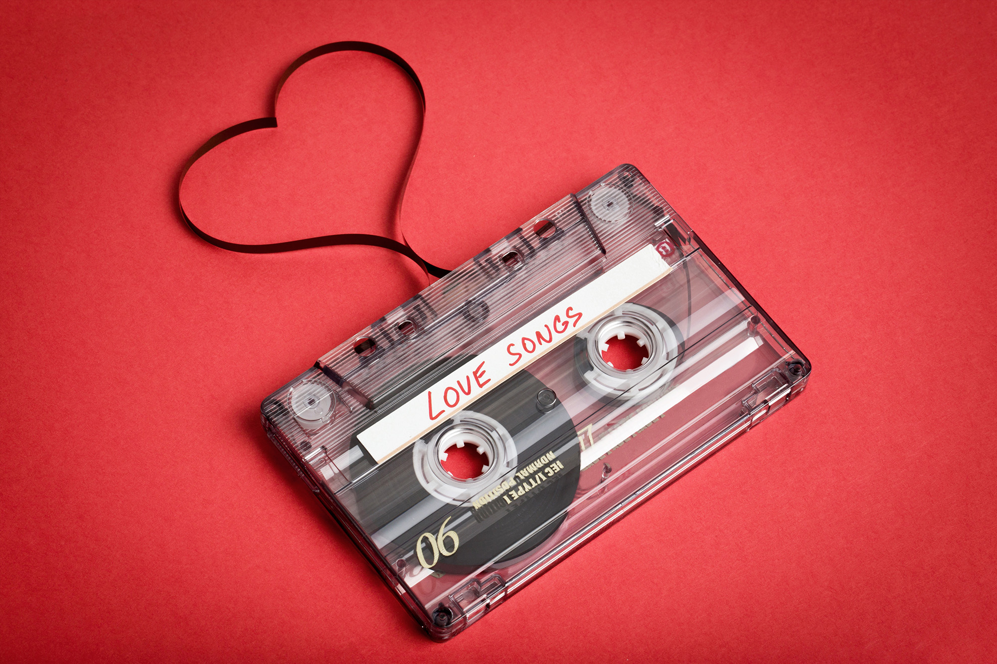 Audio cassette tape on red backgound. Film shaping heart