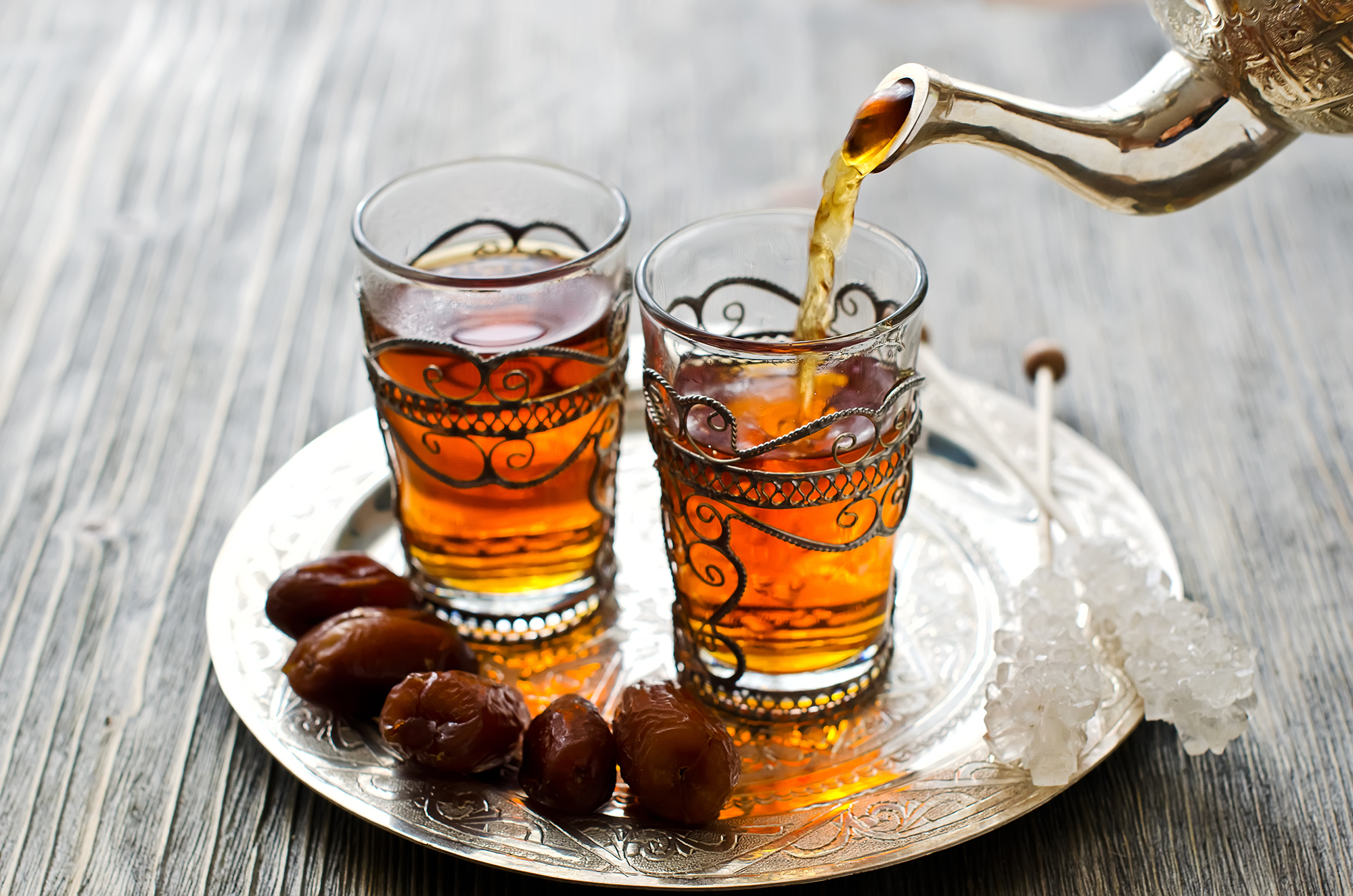Traditional arabic tea with dates and sugar on a plate