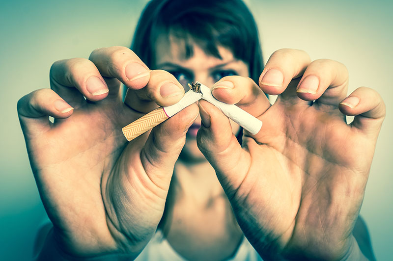 Woman with broken cigarette – stop smoking concept