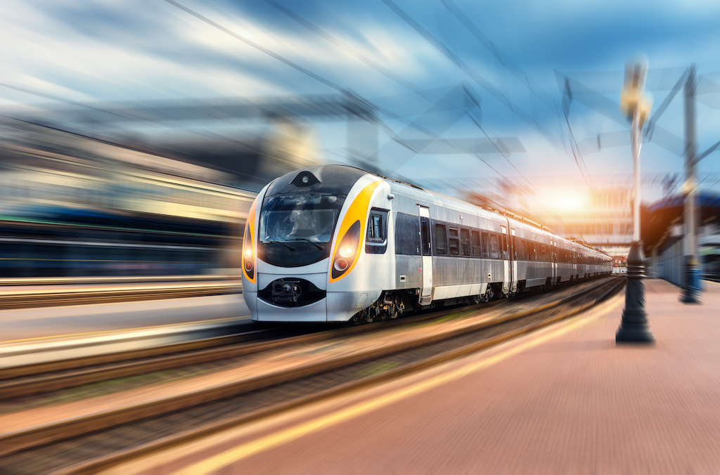 High speed train in motion at the railway station at sunset